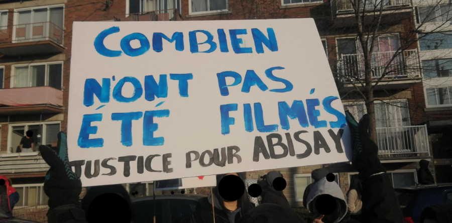 Image d'une personne manifestant avec une affiche sur laquelle on peut lire : "Combien n'ont pas été filmés - Justice pour Abisay"